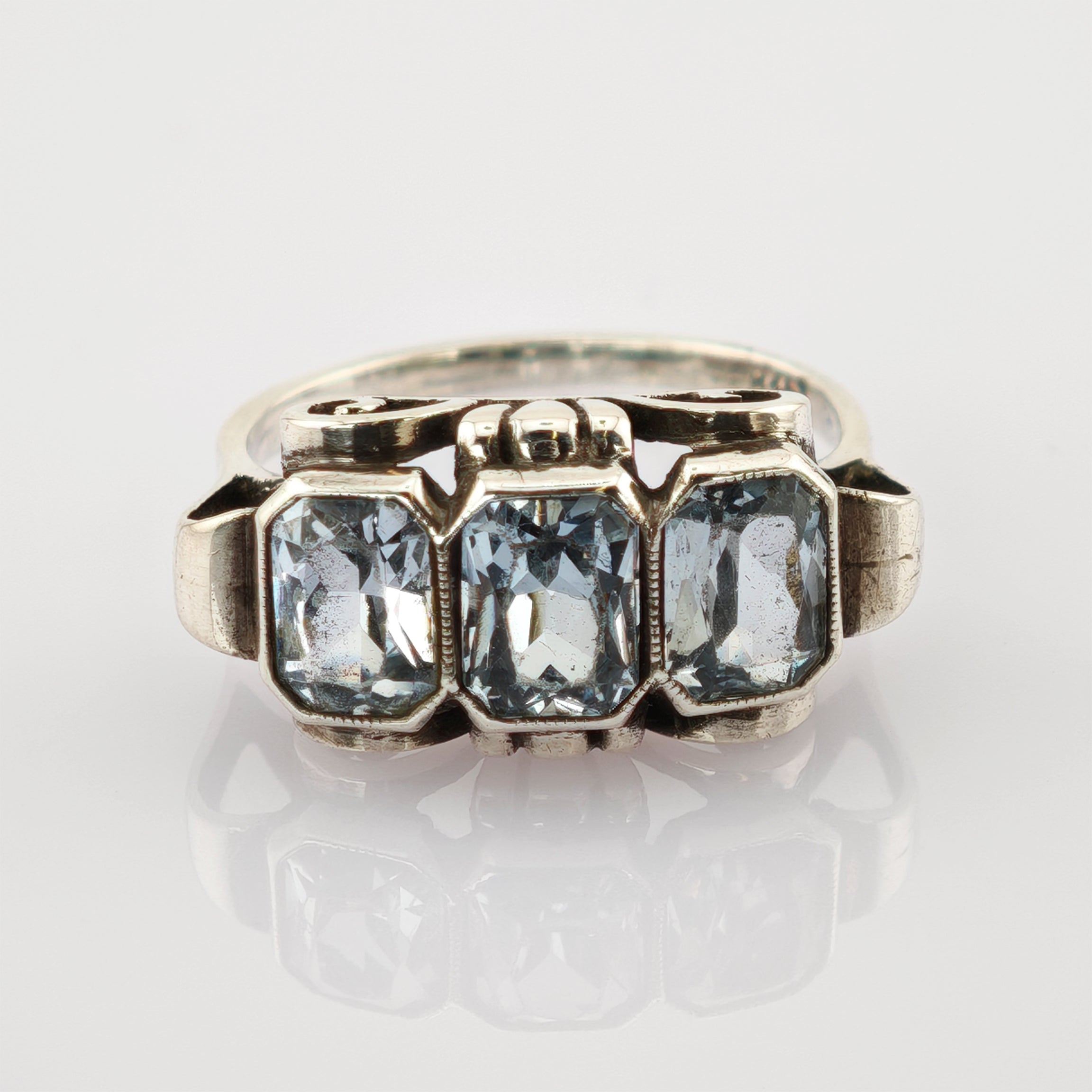 Silberner Vintage-Ring mit drei rechteckigen hellblauen facettierten Steinen und filigranen Metallarbeiten.