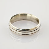 Silberner Vintage-Ring mit zwei parallelen Rillen auf reflektierender Oberfläche.