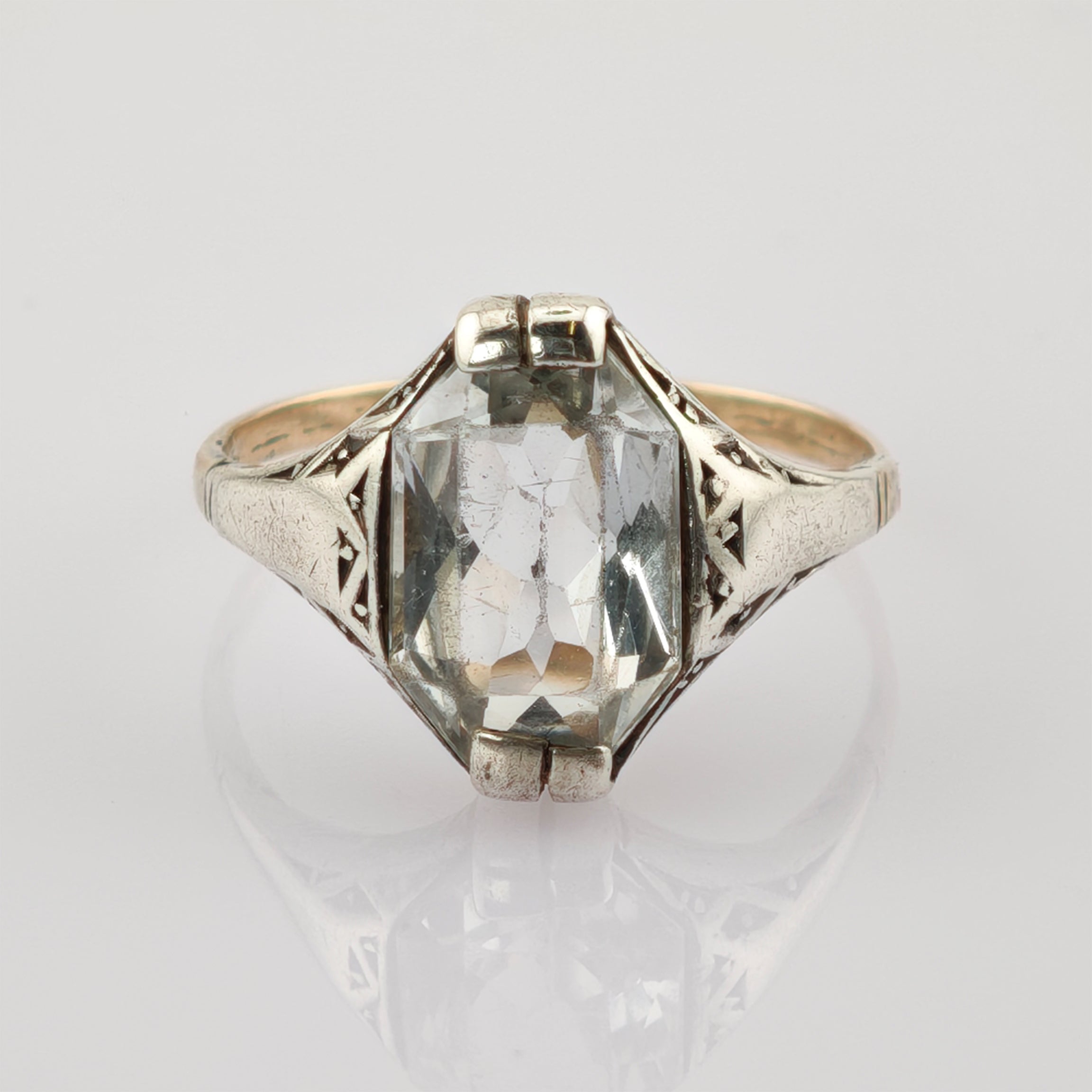 Silberner Vintage-Ring mit Gravuren und rechteckigem Edelstein auf grauem Hintergrund