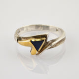 Silberring mit asymmetrischem Design, goldfarbenem Herz und dreieckigem dunkelblauem Stein.