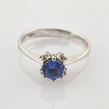 Silberring mit rundem blauem Edelstein und zwei kleinen klaren Steinen, geprägt mit 375 Reinheitsstempel.