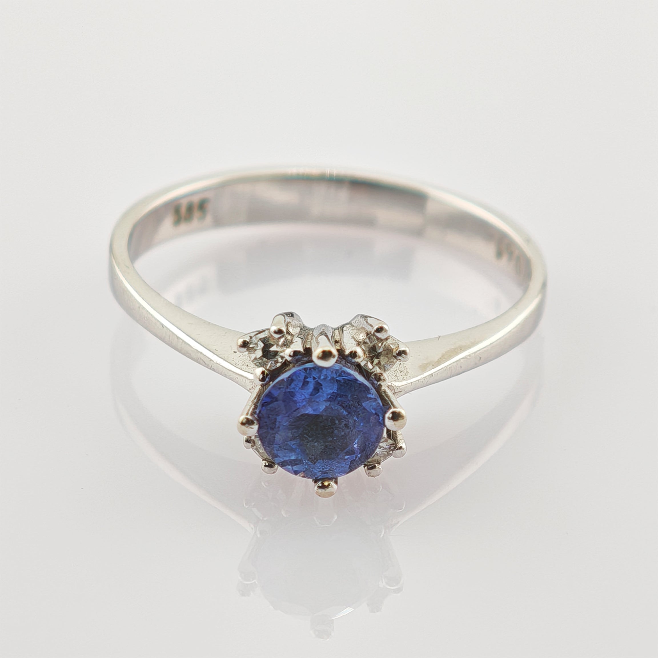 Silberring mit rundem blauem Edelstein und zwei kleinen klaren Steinen, geprägt mit 375 Reinheitsstempel.