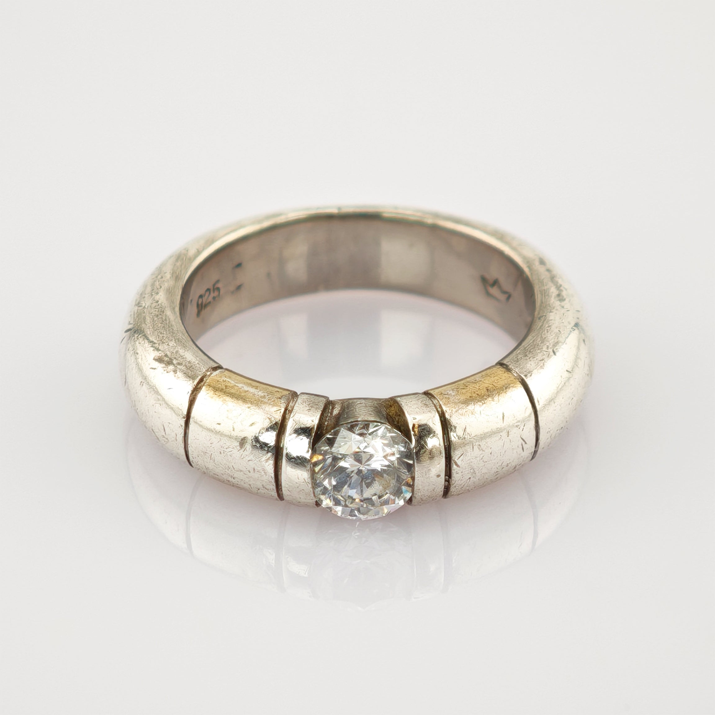 Silberring mit breitem Band, klarer Rundschliff-Edelstein in der Mitte, 925er Silberpunze innen.