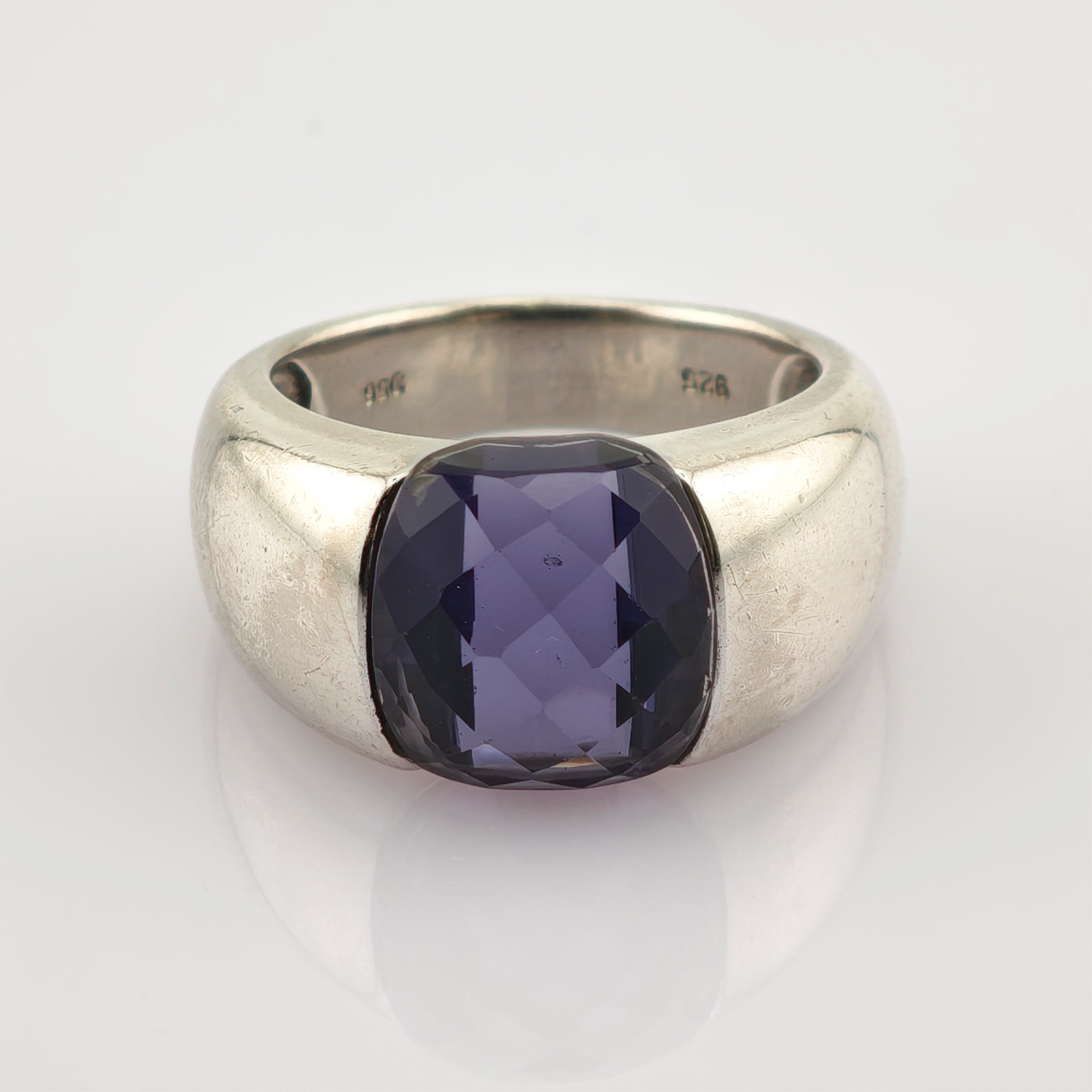 Silberring mit breitem Band und großem, quadratisch facettiertem violettem Edelstein, mit 925 gestempelt.