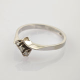 Eleganter Silberring mit drei kleinen runden Diamanten im Dreiecksmuster und gebogener Bandform.