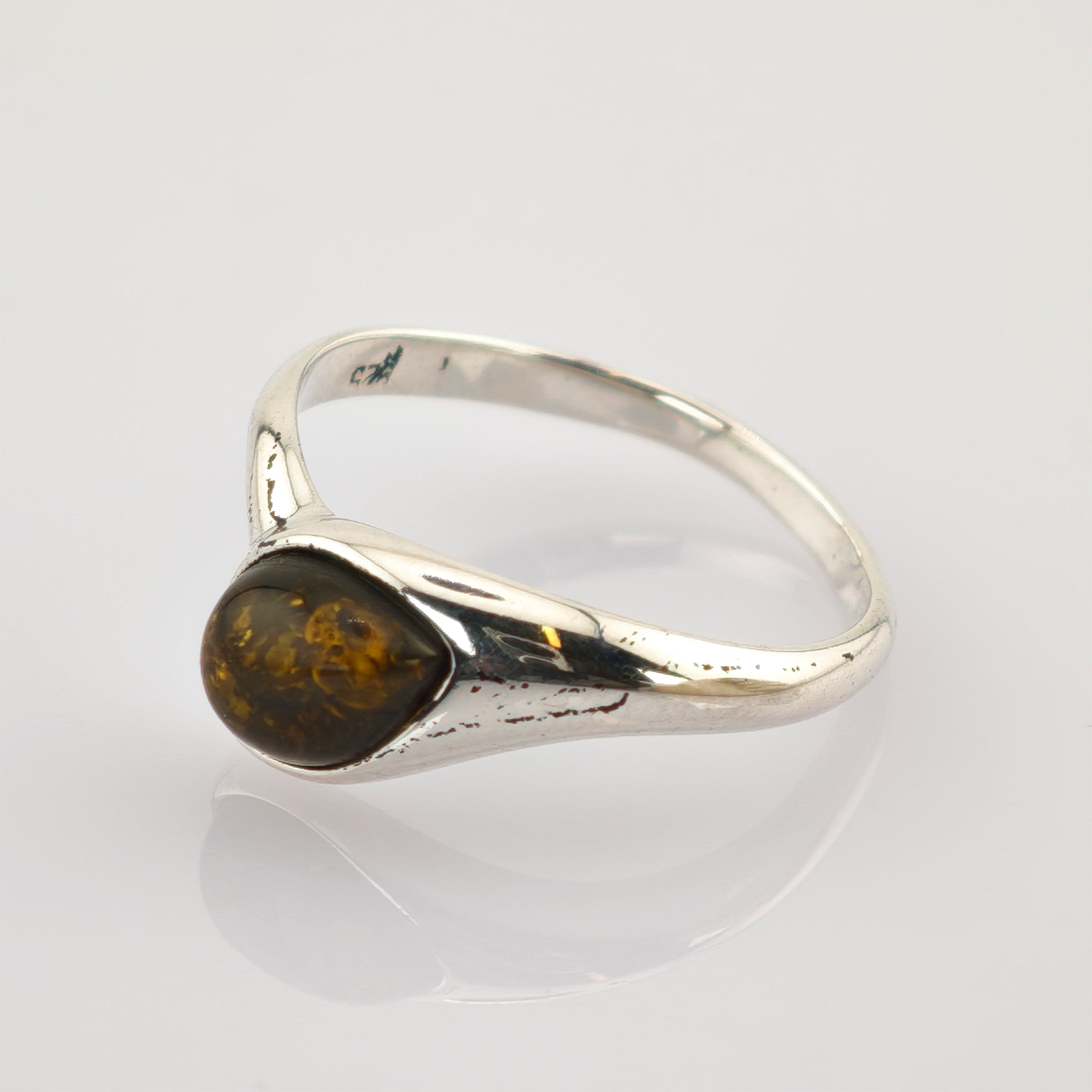 Silberring mit dreieckigem poliertem Bernstein und goldbraunen Einschlüssen auf einem glatten Silberband