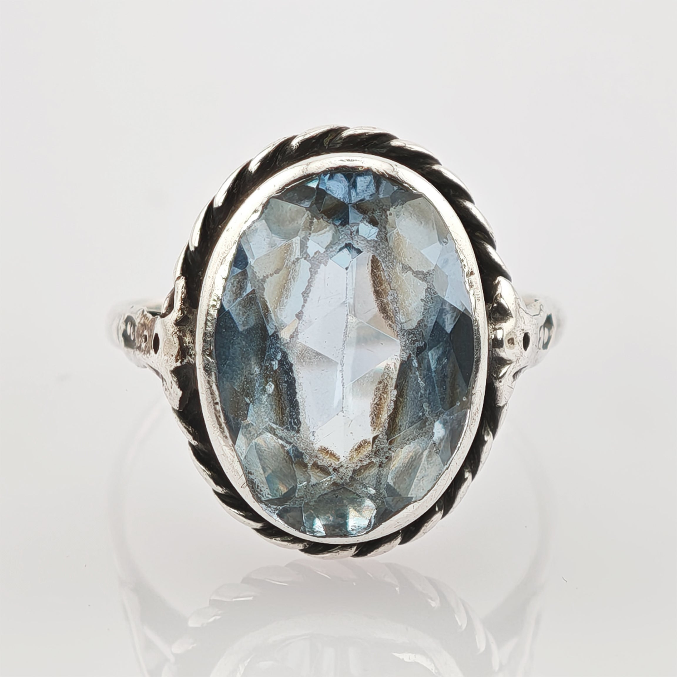 Silberring mit gedrehtem Band und ovalem blauem facettiertem Edelstein mit inneren Einschlüssen