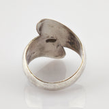 Nahaufnahme eines silbernen Rings mit offenem Blattdesign und antiker Patina.