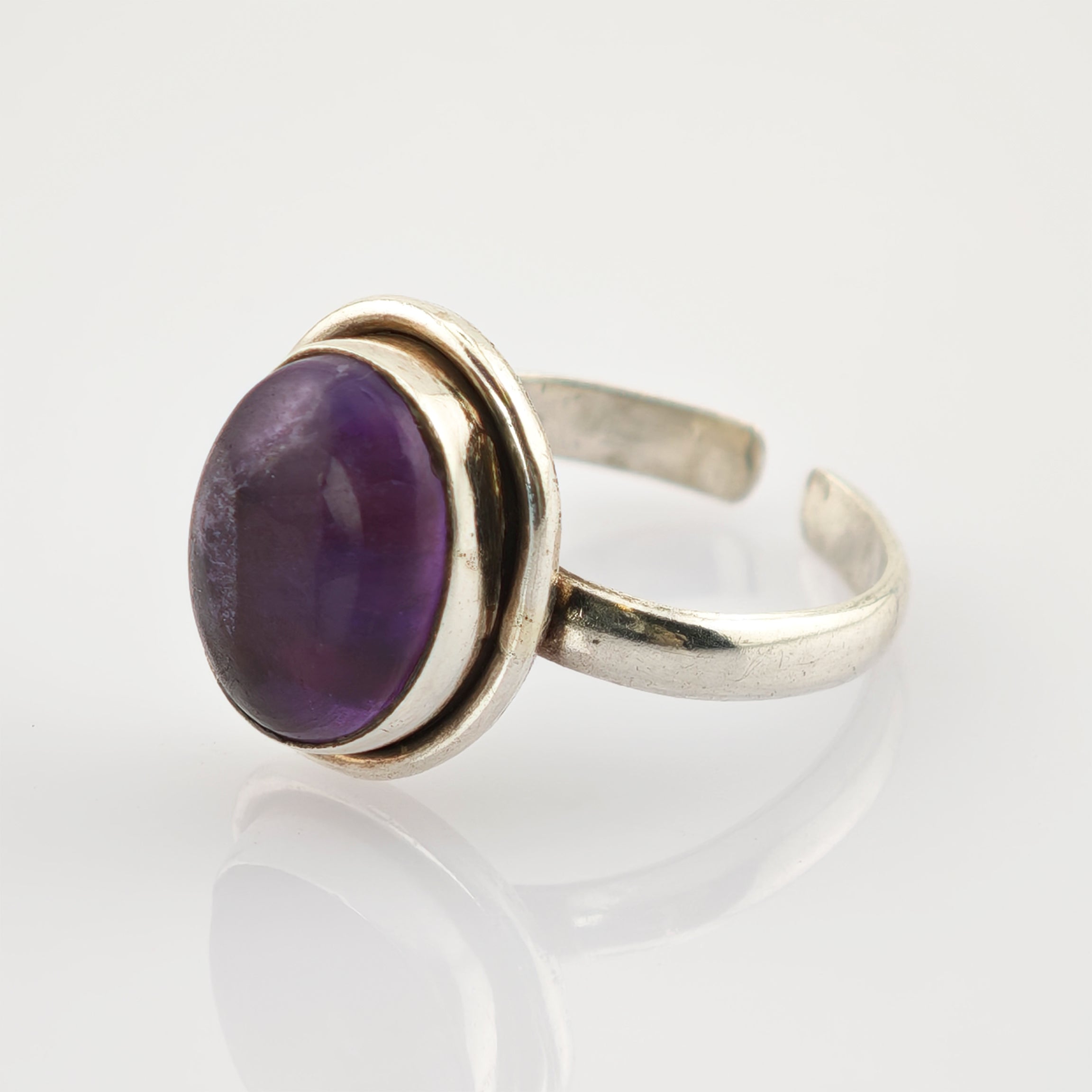 Silberring mit offenem Band und ovalem lila Amethyst, vintage Schmuckdesign.