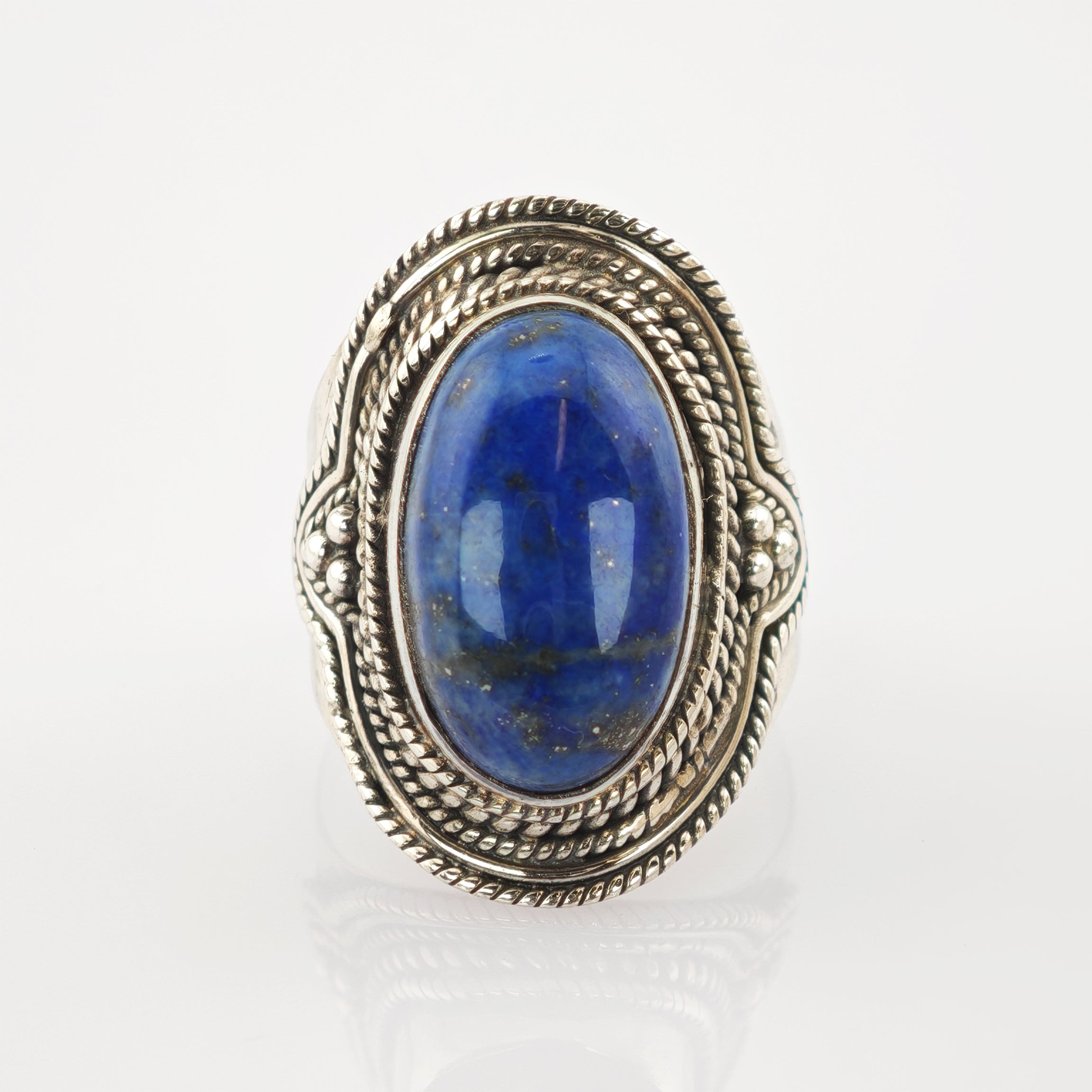 Silberring mit ovalem blauem Edelstein und Seil- und Perlenmuster auf weißem Hintergrund
