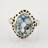 Silberring mit ovalem blauen Edelstein und kunstvollen Ausschnitten am Band