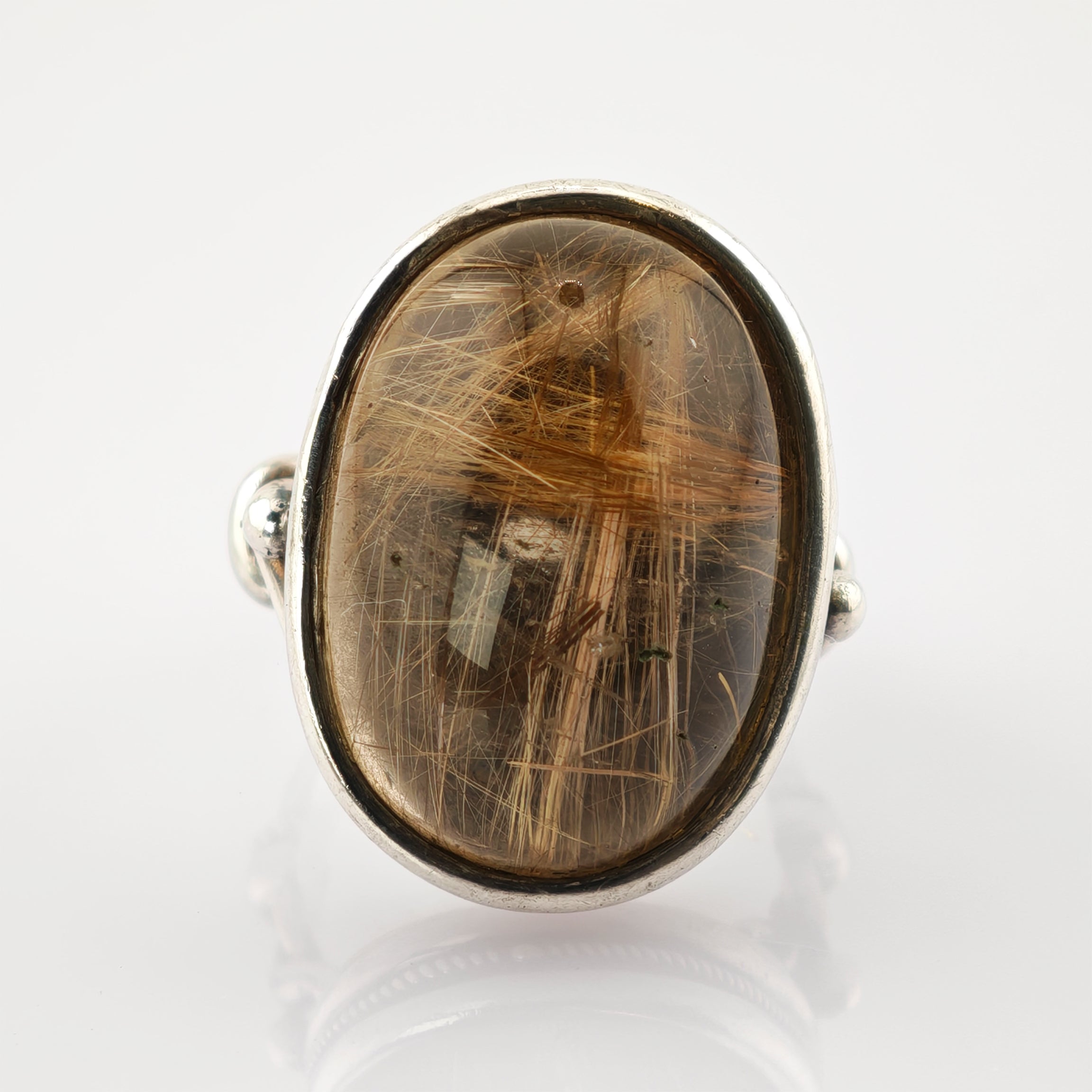 Silberring mit ovalem Cabochon-Stein und feinen goldenen Rutilnadeln im glatten Fassungsdesign.