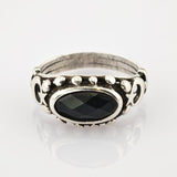 Silberring mit ovalem schwarzen Stein und mondförmigen Verzierungen aus kleinen silbernen Nieten