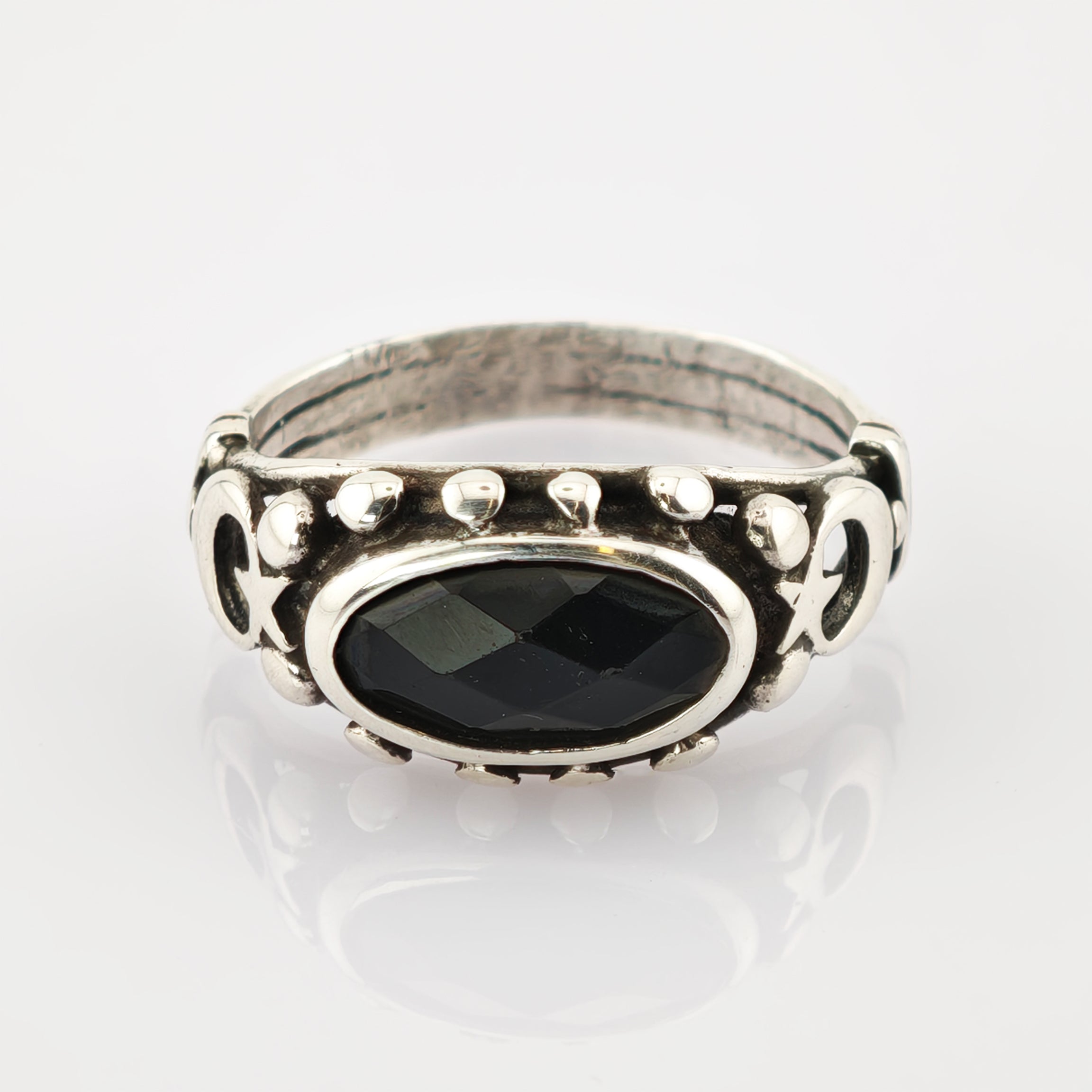Silberring mit ovalem schwarzen Stein und mondförmigen Verzierungen aus kleinen silbernen Nieten
