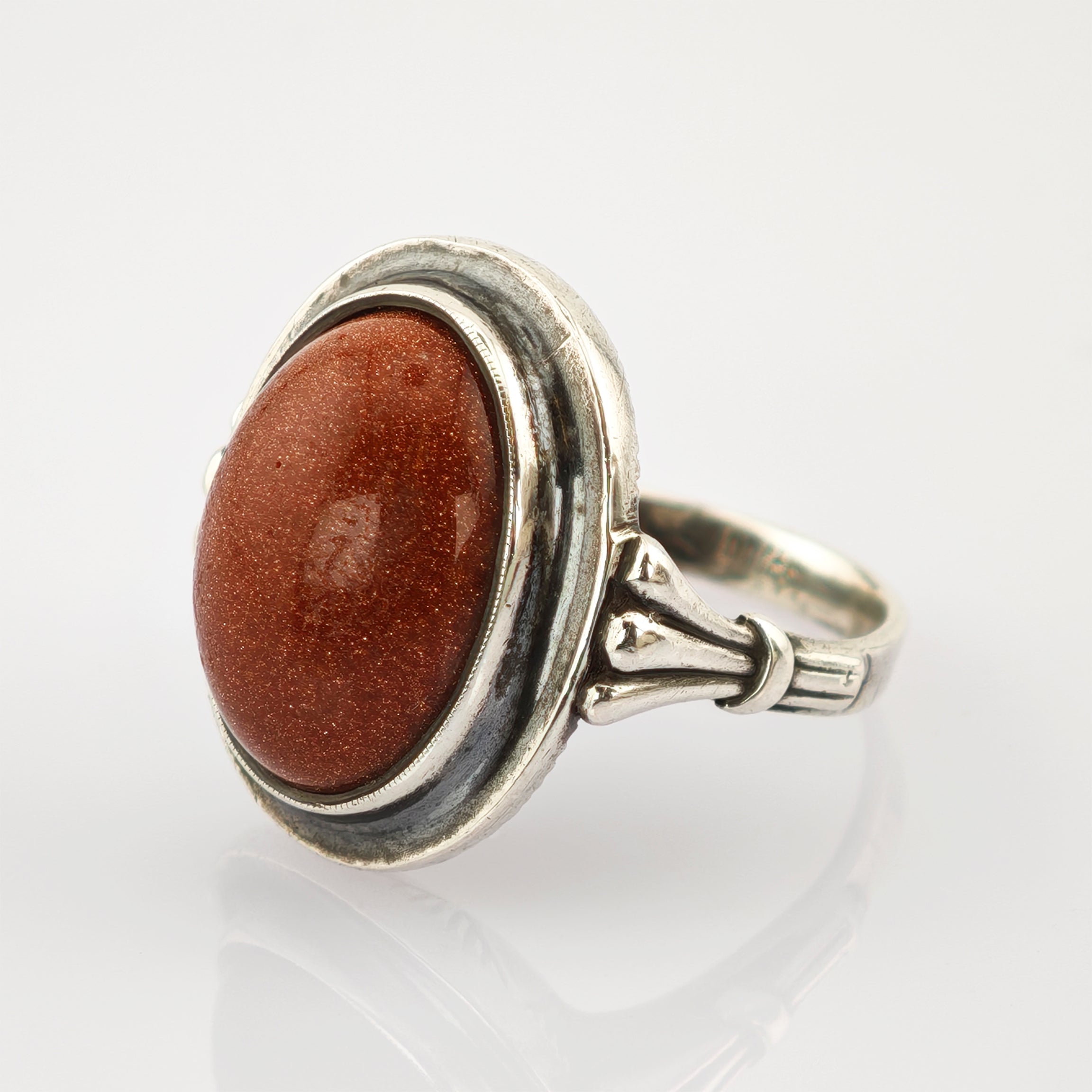 Silberring mit ovalem rötlich-braunem Edelstein und verziertem Band