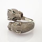 Silberring mit zwei Pantherköpfen, besetzt mit Diamanten und grünen Edelsteinaugen