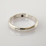 Schlichter Silberring mit polierter Oberfläche auf einer glänzenden weißen Fläche.