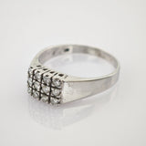 Silberring mit rechteckiger Oberseite und zwölf kleinen weißen Edelsteinen in drei Silberring mit rechteckigem Oberteil, besetzt mit einem Cluster aus zwölf kleinen Diamanten in drei Reihen.