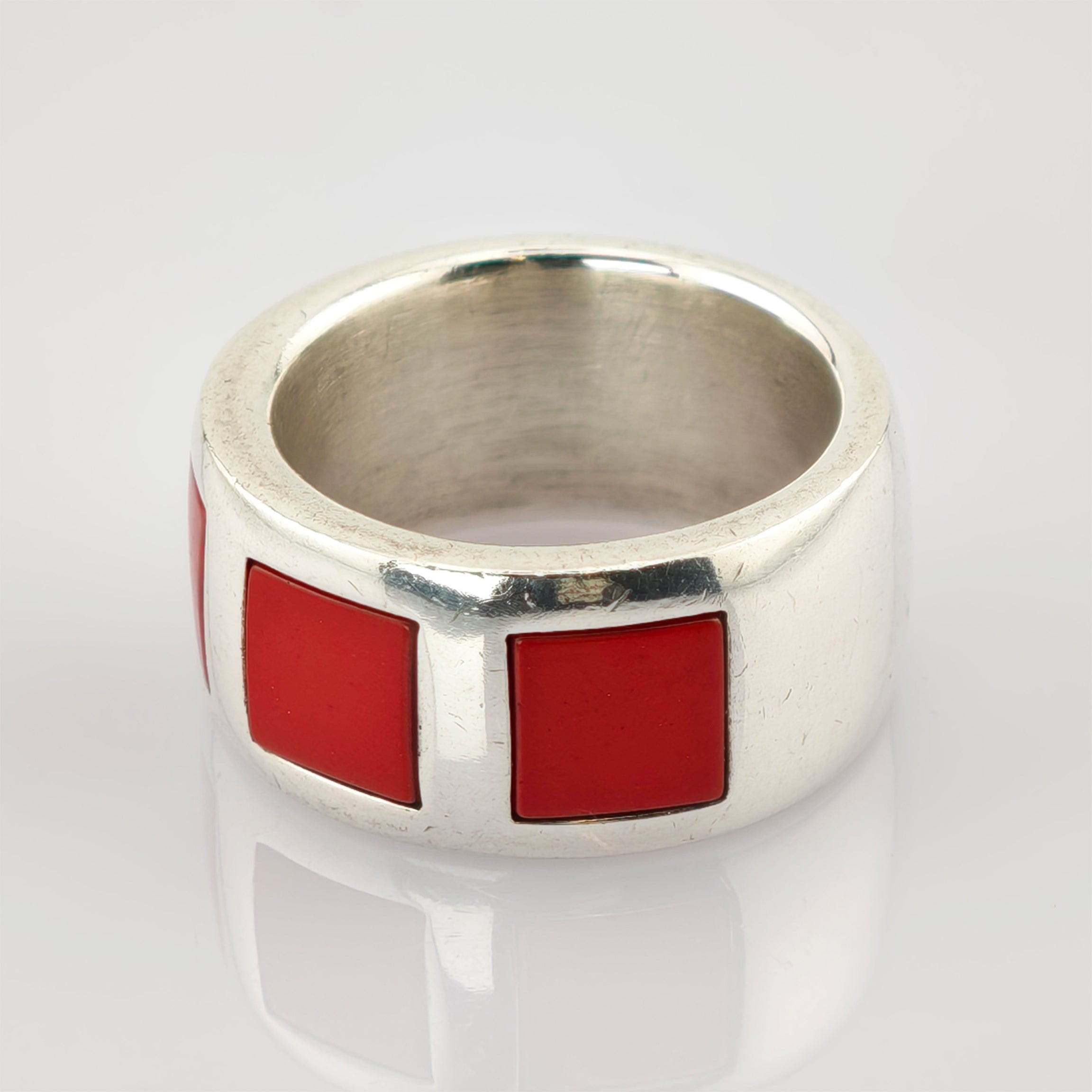 Breiter silberfarbener Ring mit drei quadratischen roten Emaillinien, modernes geometrisches Design.