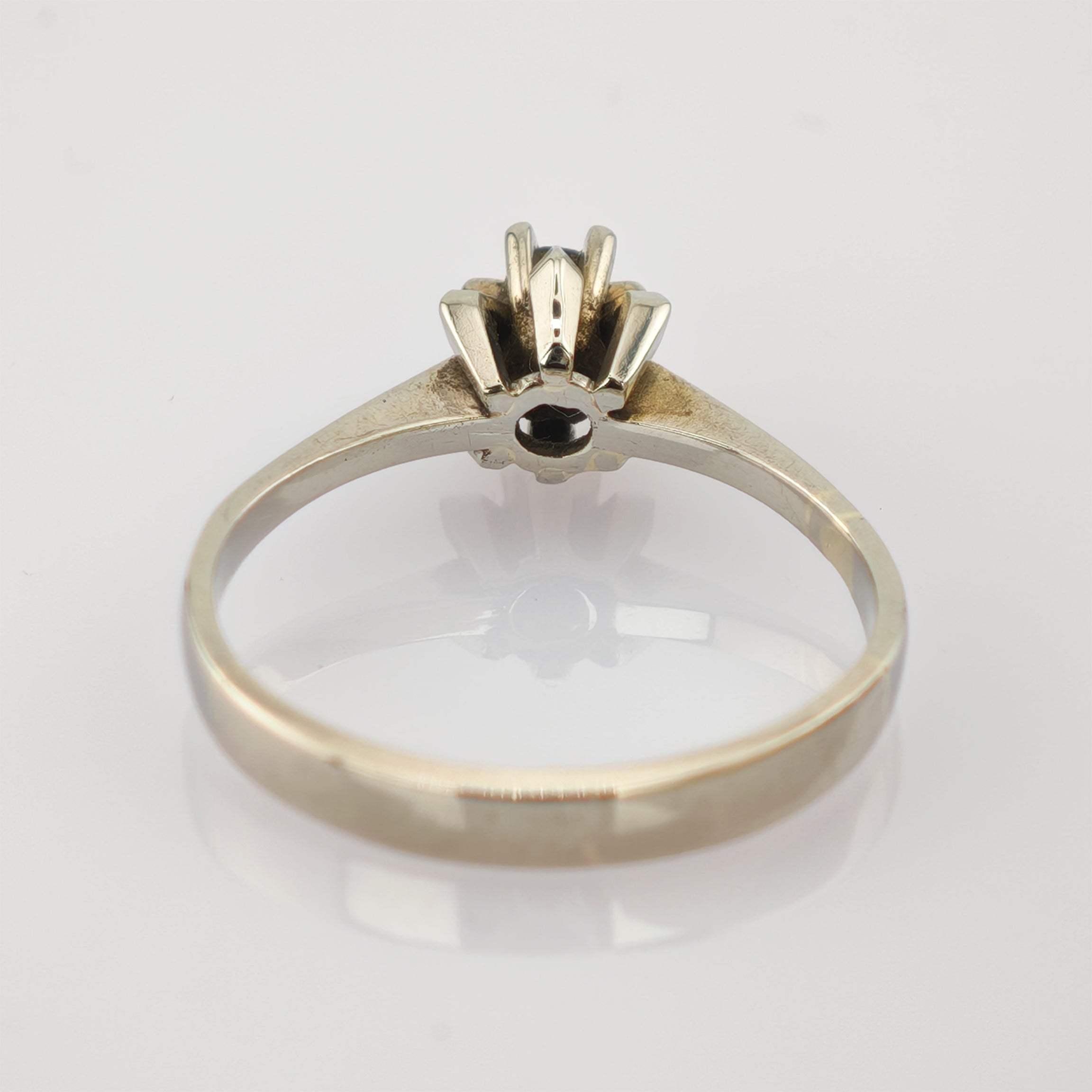 Silberfarbener Ring mit kleinem schwarzem Edelstein in sechszackiger Fassung.