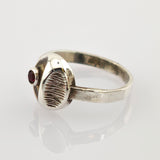 Silberring mit strukturiertem ovalem Mittelteil und kleinem rundem rotem Edelstein