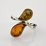 Silberring mit zwei Bernsteinen in Tropfenform auf gedrehtem Band mit dreieckigen Aussparungen.