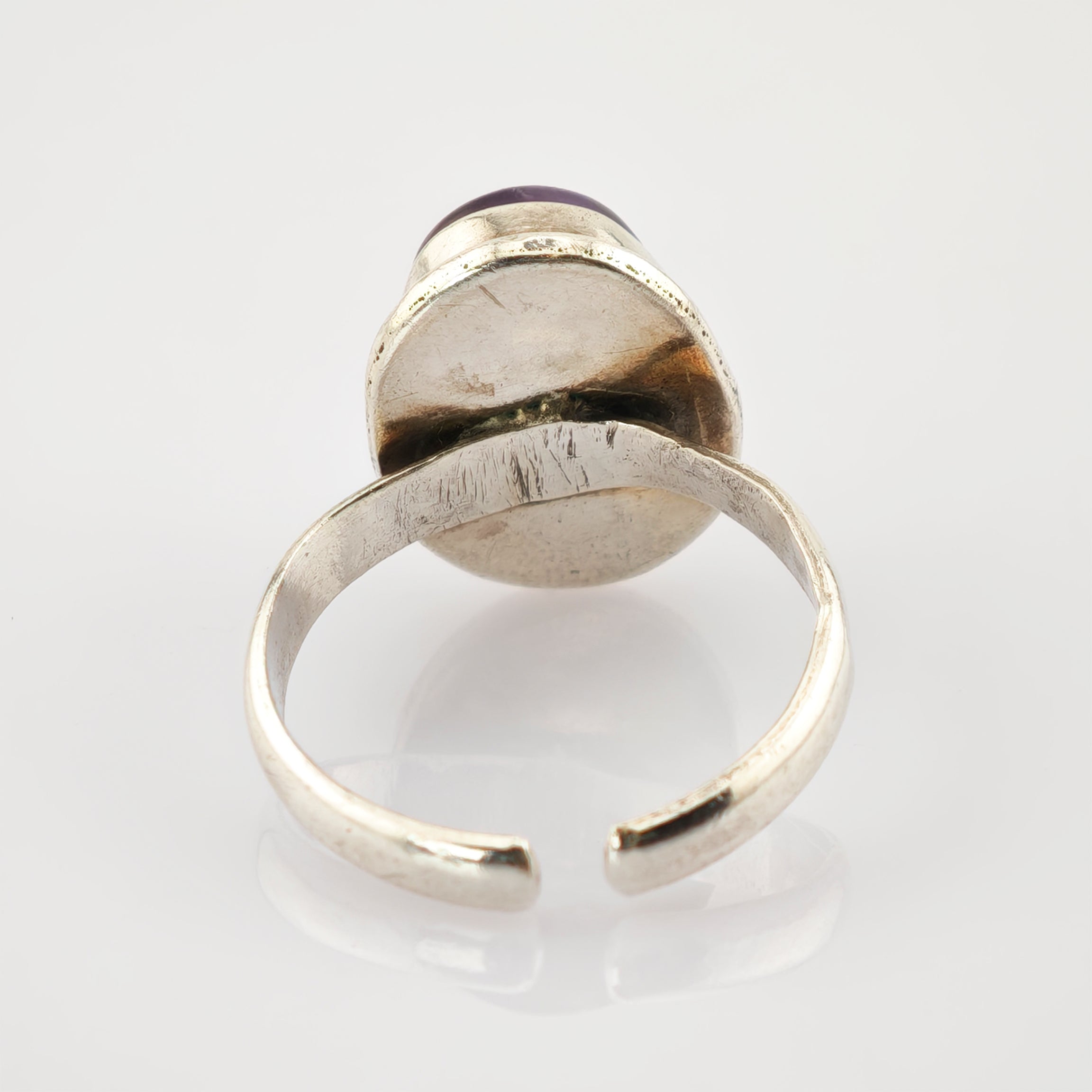 Verstellbarer Silberring mit rundem Amethyst und sichtbaren Kratzern.