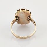 Nahaufnahme eines Vintage-Goldrings mit Muschel-Design und sichtbaren Gebrauchsspuren