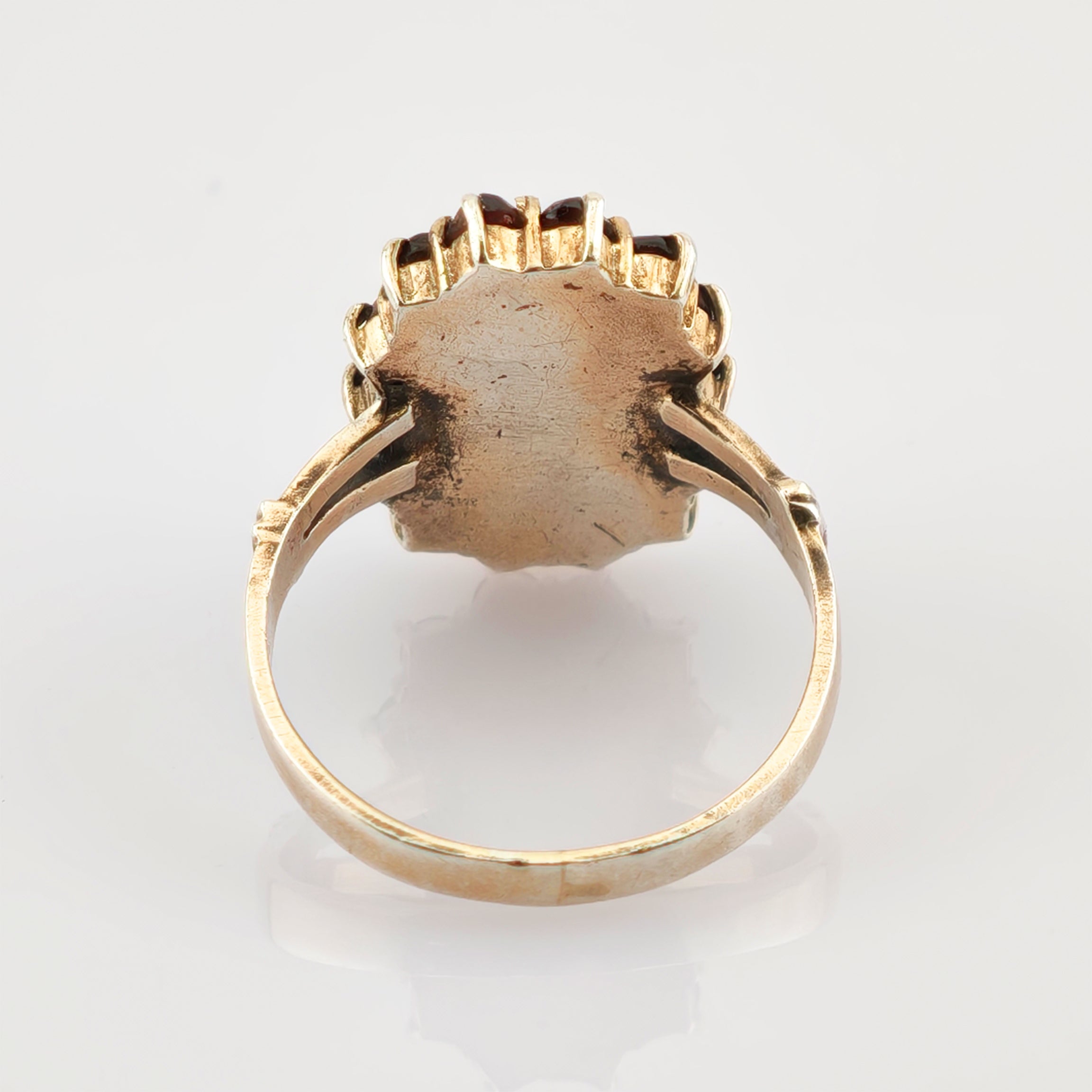 Nahaufnahme eines Vintage-Goldrings mit Muschel-Design und sichtbaren Gebrauchsspuren