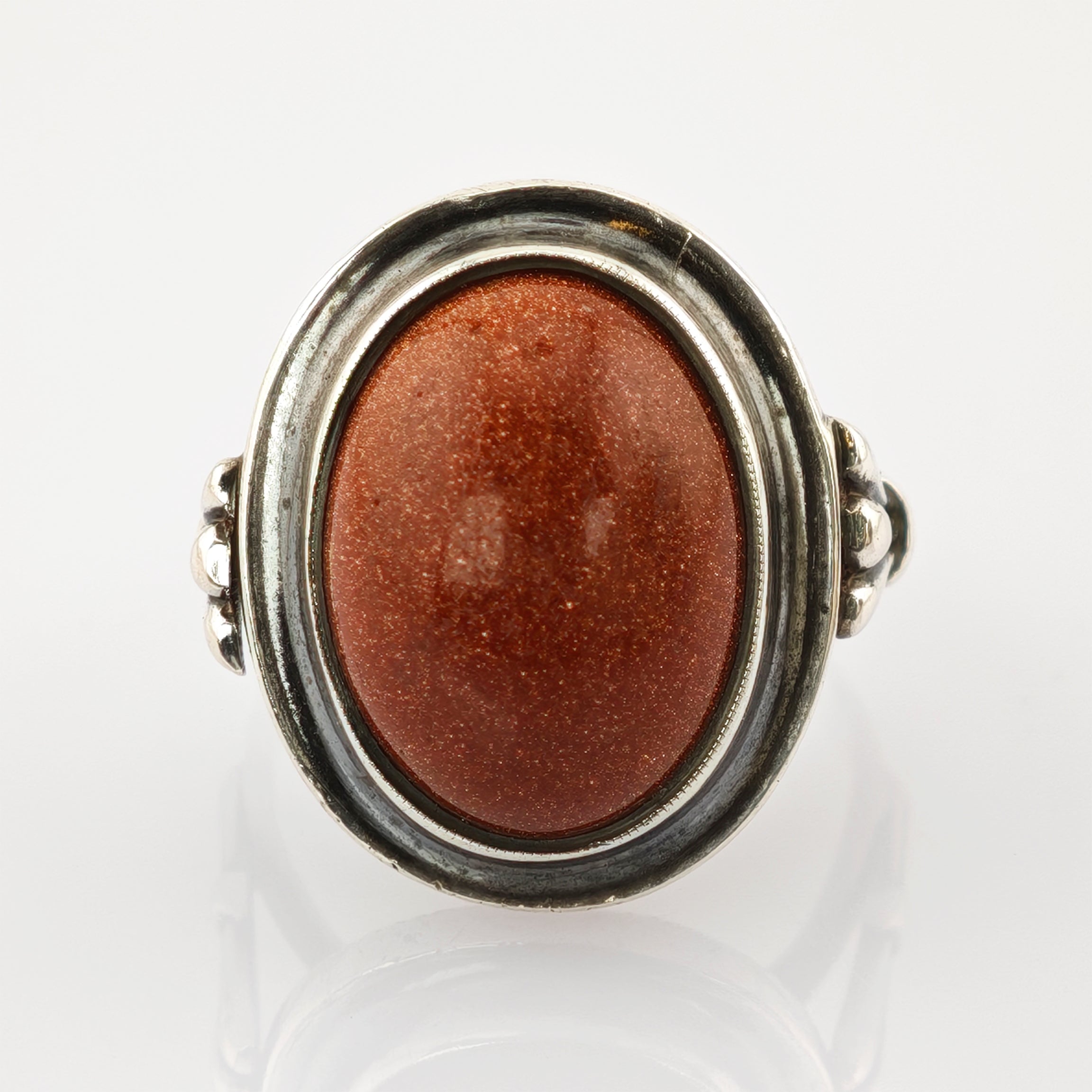 Vintage Silberring mit ovalem, rötlich-braunem glitzerndem Stein und dekorativem Band.