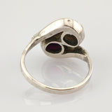 Vintage Silberring mit zwei tropfenförmigen Fassungen, eine mit tiefrotem Edelstein und eine dunkle Leerfassung.
