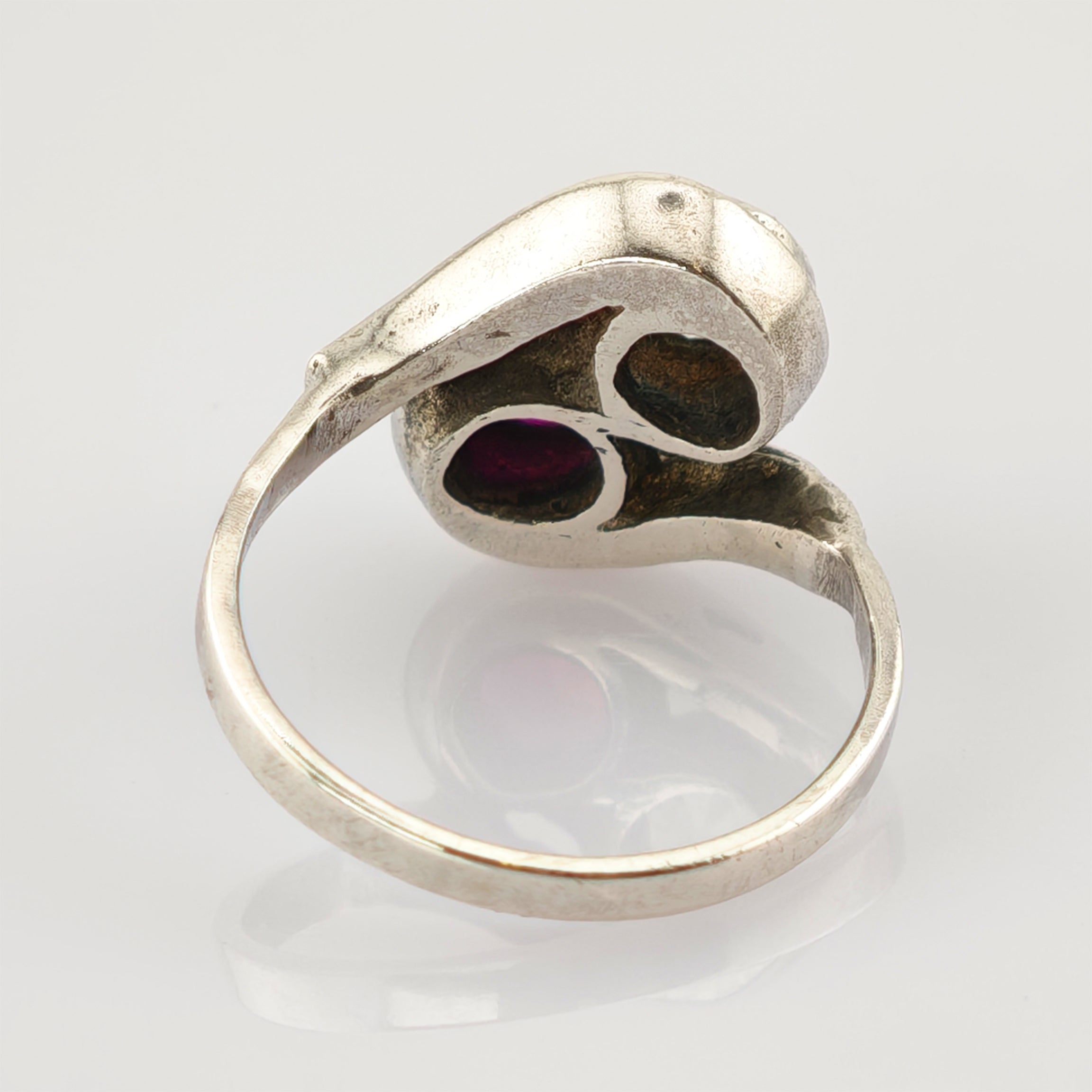 Vintage Silberring mit zwei tropfenförmigen Fassungen, eine mit tiefrotem Edelstein und eine dunkle Leerfassung.