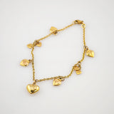 Zartes Goldarmband mit sieben herzförmigen Anhängern und Karabinerverschluss.