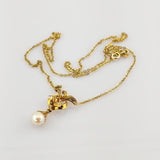 Zartes Goldkettchen mit elegantem Anhänger und großem weißen Perltropfen.