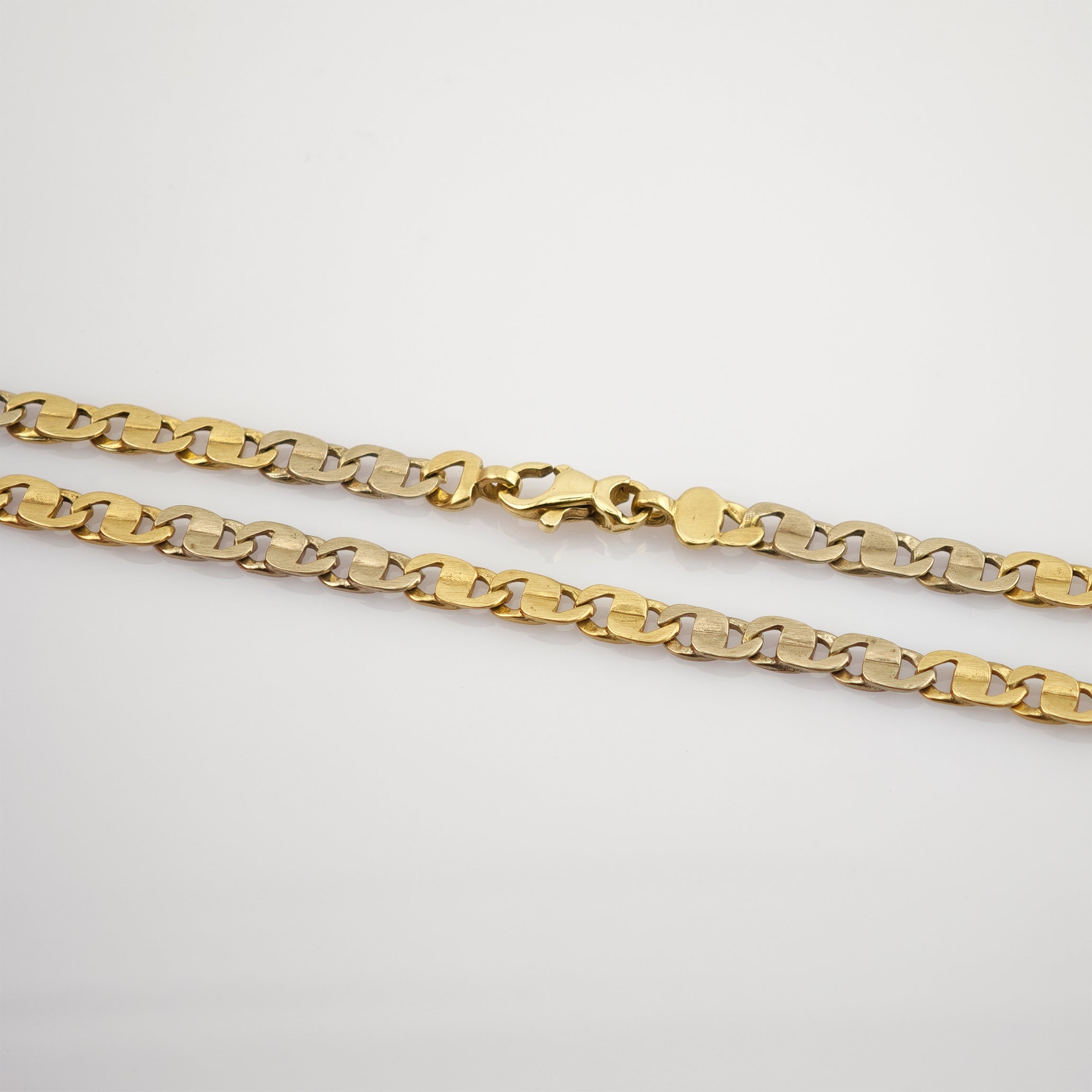 Zweifarbige Metallkette mit gold- und silberfarbenen flachen Gliedern und mittigem Karabinerverschluss.